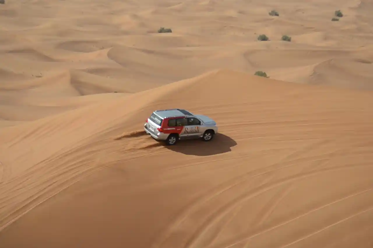 4x4 vehicle climbing sand dunes during a morning desert safari in Dubai