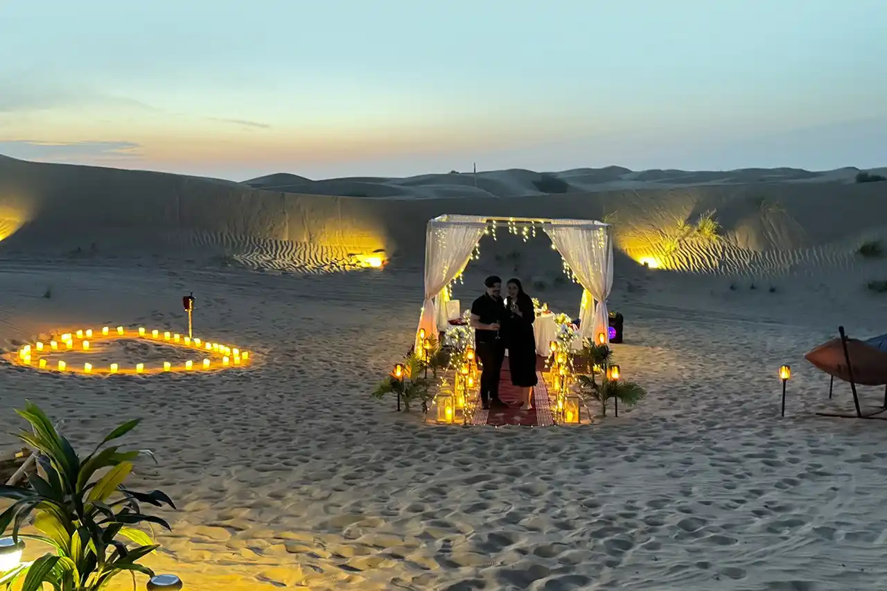 Couple enjoying a romantic candlelight dinner in the serene Dubai desert under the stars