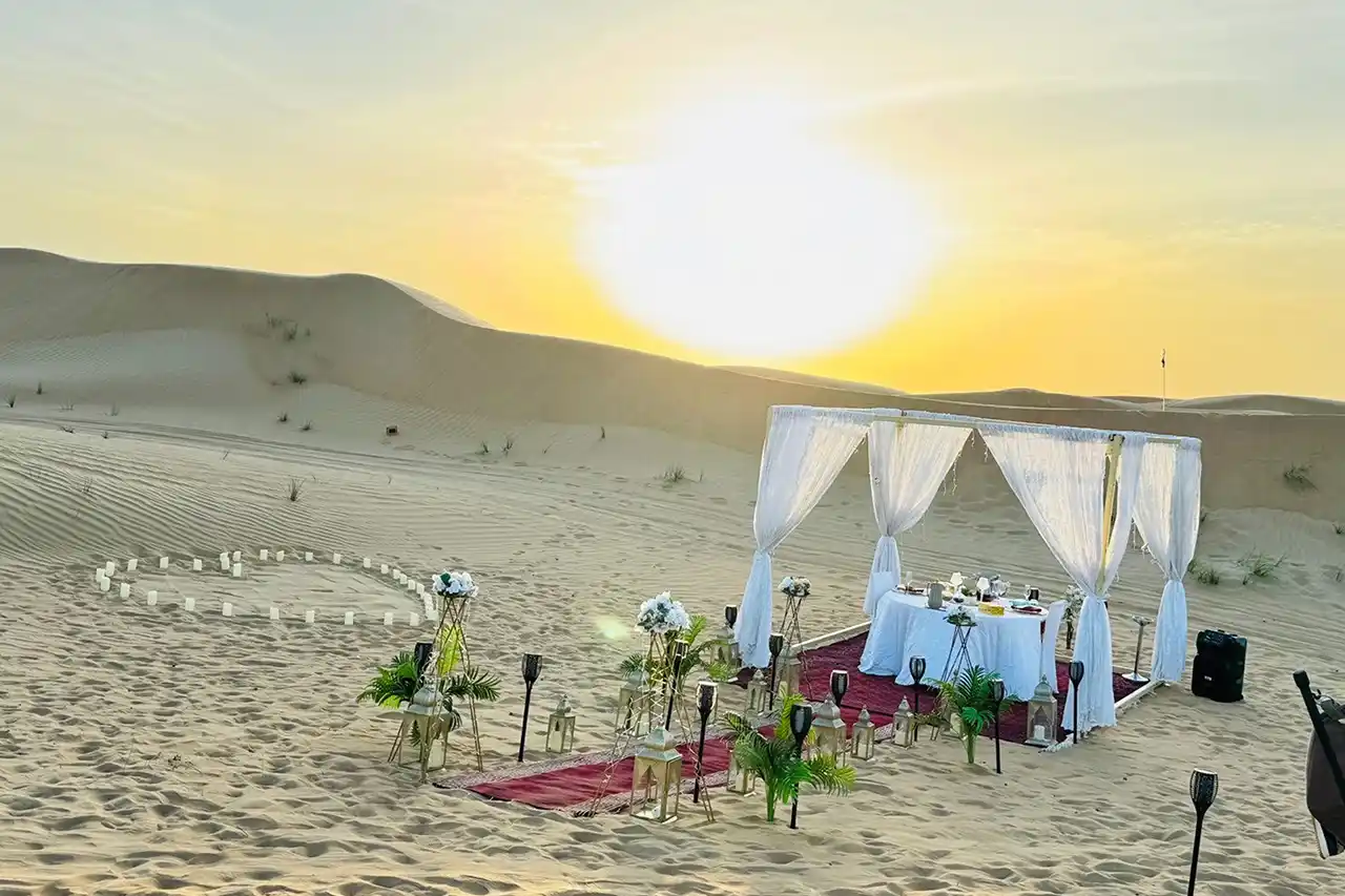 Private romantic dinner setup for two in the peaceful Dubai desert during sunset