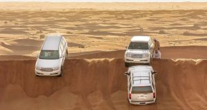 3 White color SUV on the sand at Dubai Desert Safari.