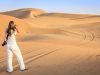 A woman taking photos at desert safari Dubai.