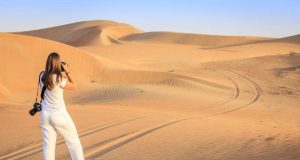 A woman taking photos at desert safari Dubai.