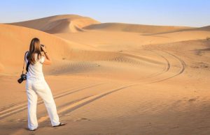 A woman taking photos at desert safari Dubai.